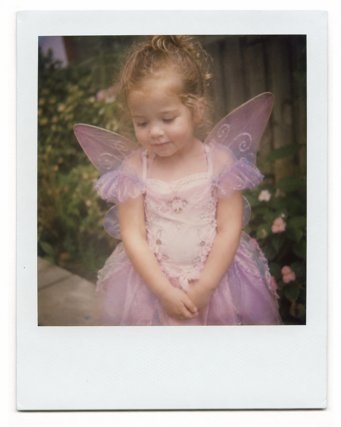 Amelia Rose dressed as a fairy in a flower-filled garden